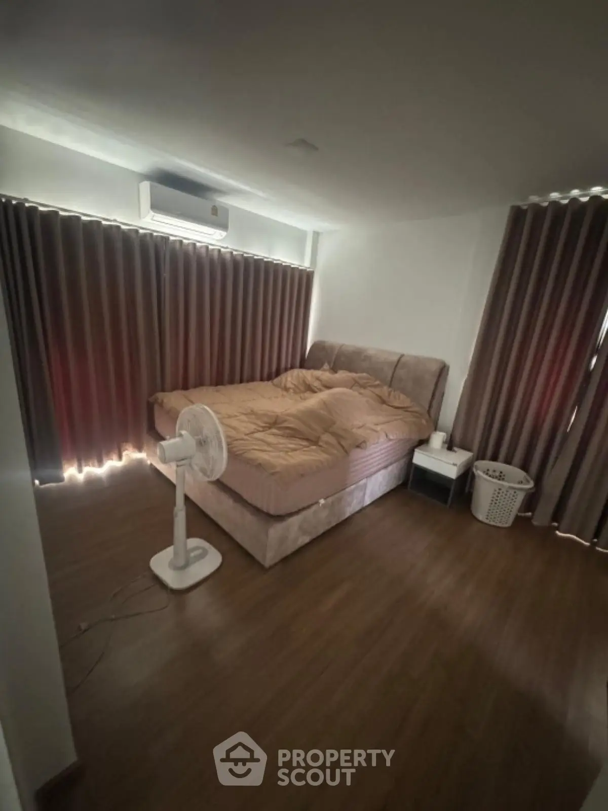 Cozy bedroom with modern decor and natural light, featuring a comfortable bed and stylish curtains.