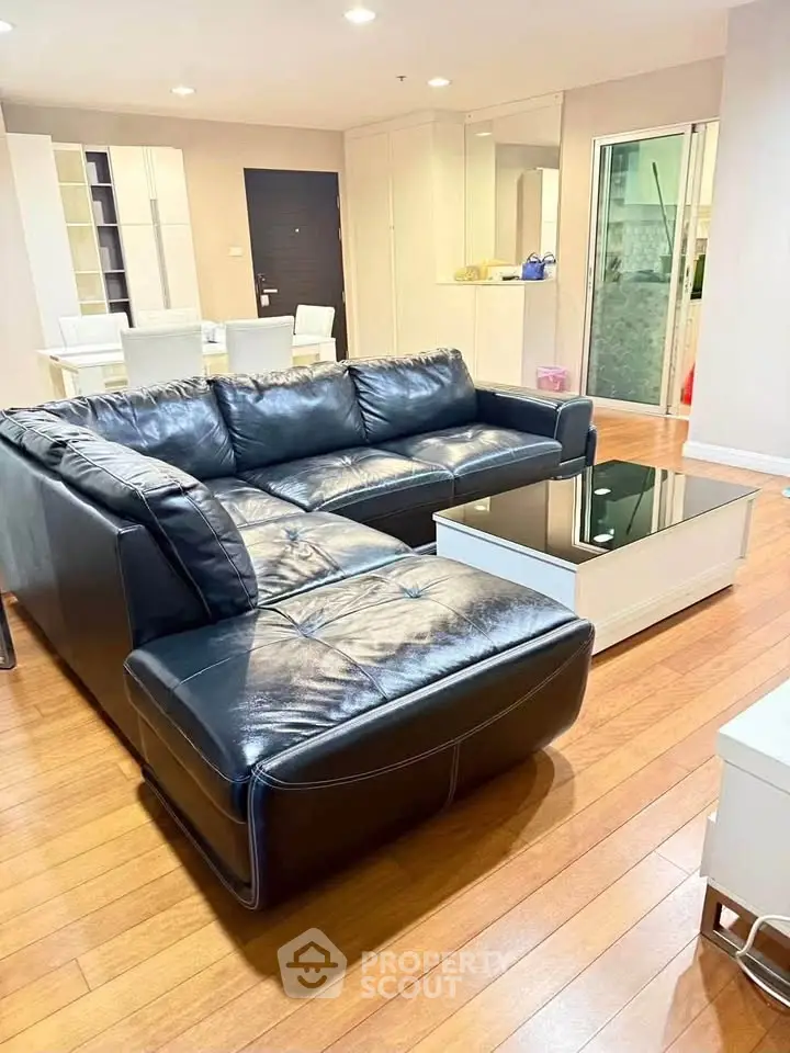 Spacious living room with elegant black leather sofa and modern decor