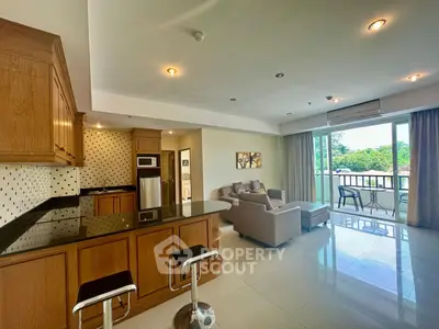 Spacious open-plan living room with modern kitchen and balcony view