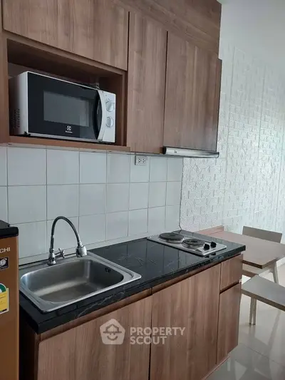 Modern kitchen with wooden cabinets and sleek appliances in a stylish apartment.