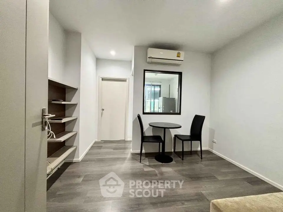 Modern minimalist apartment interior with sleek flooring and compact dining area.