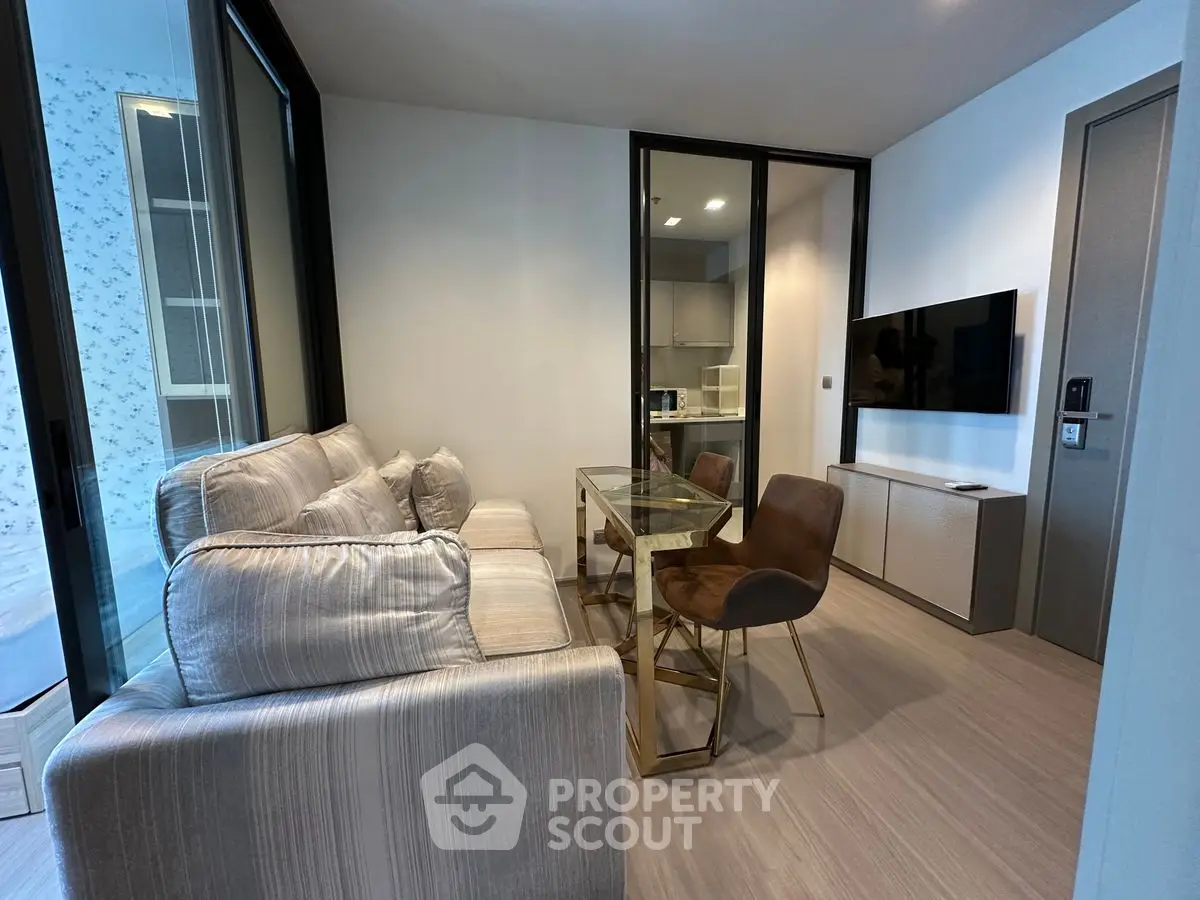 Modern living room with cozy sofa and glass dining table in stylish apartment.