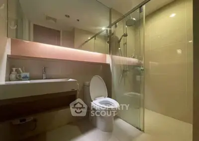 Modern bathroom with glass shower and sleek fixtures in a contemporary apartment.