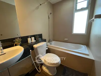 Modern bathroom with sleek fixtures and a bathtub, featuring a large window for natural light.
