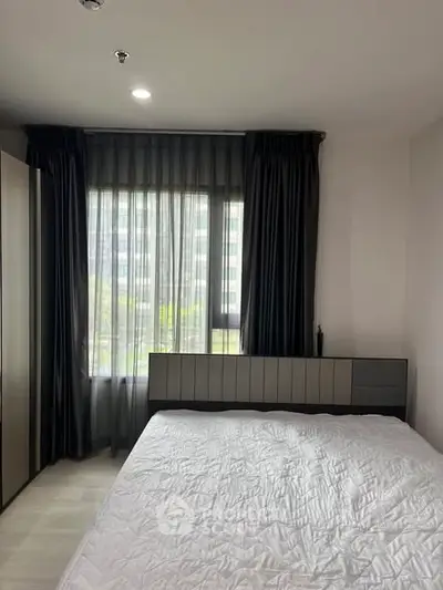 Modern bedroom with large window and stylish curtains in a contemporary apartment.