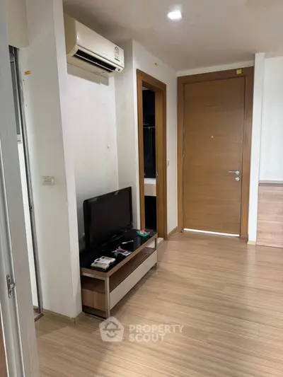 Modern living room with wooden flooring and sleek TV setup