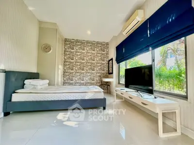 Modern bedroom with stylish decor and large windows for natural light.