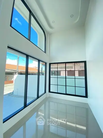 Stunning modern living room with high ceilings and large windows offering abundant natural light.