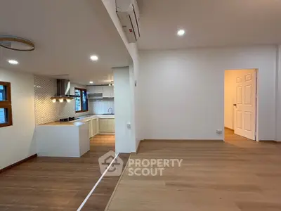 Spacious open-plan living room with modern kitchen and wooden flooring