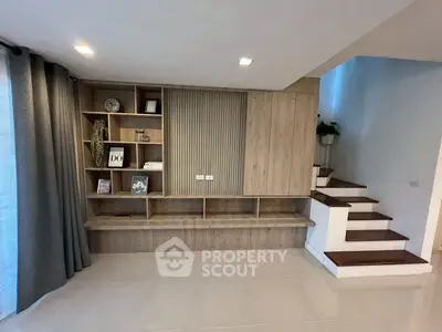 Modern living room with stylish wooden shelving and elegant staircase