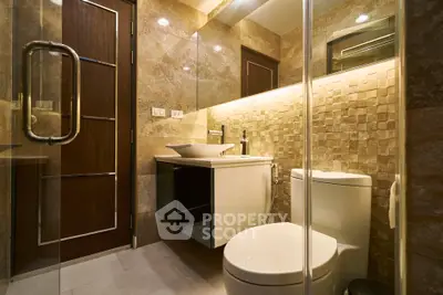 Luxurious modern bathroom with elegant stone tiles and glass shower enclosure.