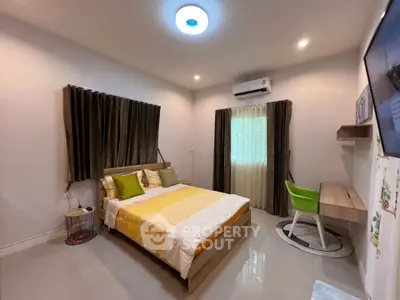 Modern bedroom with stylish decor, featuring a cozy bed, desk, and air conditioning.