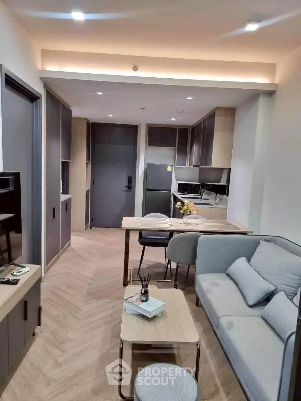 Modern open-layout living room with stylish kitchen and cozy seating area in a contemporary apartment.