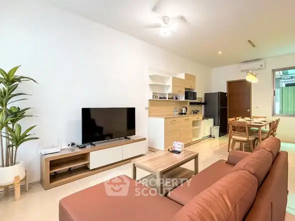 Modern open-plan living room with cozy seating and stylish kitchen area.
