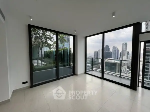 Spacious modern living room with floor-to-ceiling windows and stunning city view.