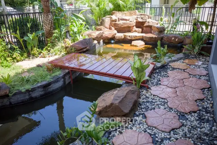 Stunning garden pond with stone pathway and lush greenery in a serene outdoor setting.
