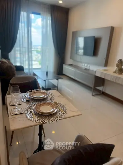 Elegant living room with modern decor and city view, featuring a stylish dining setup and wall-mounted TV.