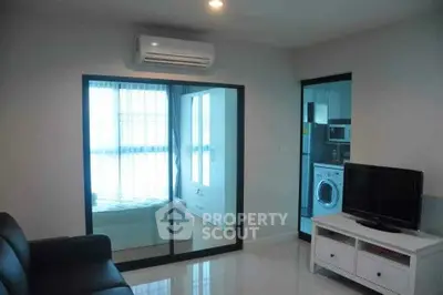 Modern apartment interior with living room and bedroom view, featuring sleek furniture and natural light.
