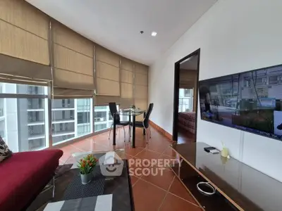 Spacious living room with modern decor and large windows offering city views.