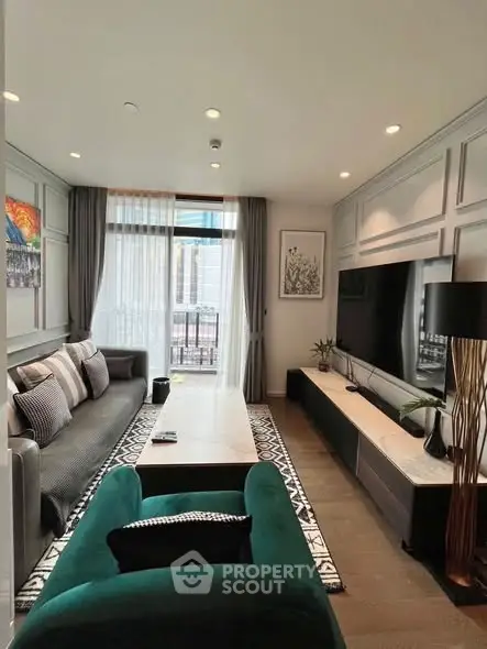 Elegant living room with modern decor, large TV, and ample natural light from floor-to-ceiling windows.