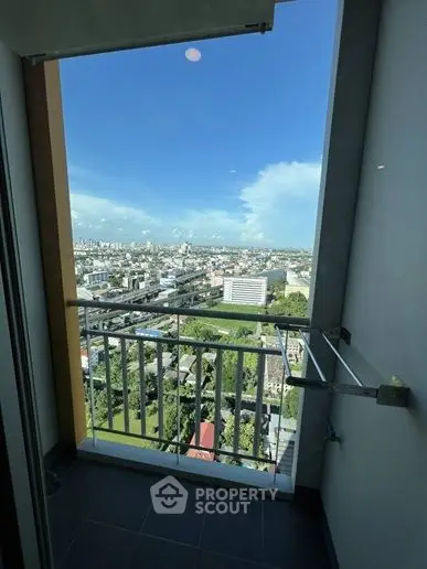 Stunning cityscape view from a high-rise balcony with clear blue skies.
