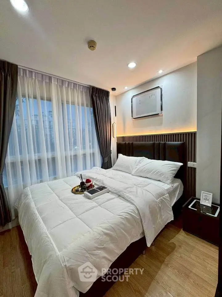 Cozy bedroom with elegant decor and large window offering natural light.