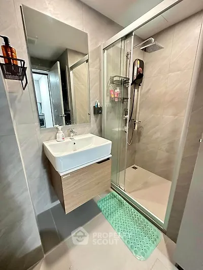 Modern bathroom with sleek shower and stylish vanity in contemporary apartment.