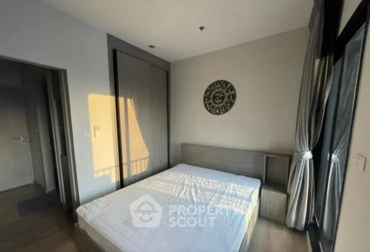 Modern bedroom with large window and stylish decor in a contemporary apartment.