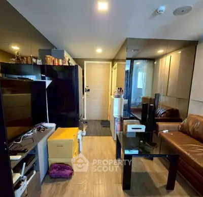 Modern living room with sleek design and glass table, featuring a cozy leather sofa and stylish decor.