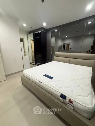 Modern bedroom with sleek design and comfortable mattress in a stylish apartment.