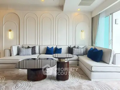 Luxurious modern living room with elegant sectional sofa and stylish coffee tables.