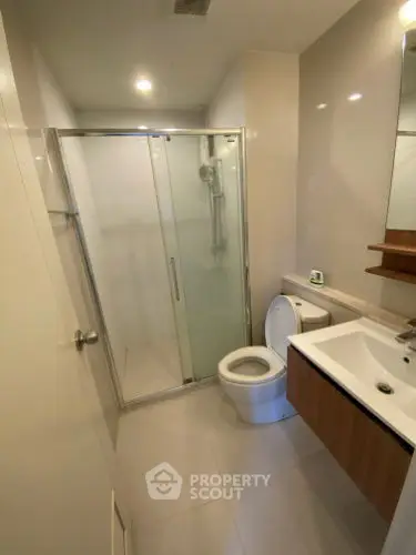 Modern bathroom with glass shower and sleek fixtures in a contemporary home.