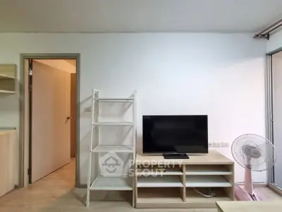 Modern living room with TV stand, open shelving, and fan in a cozy apartment.