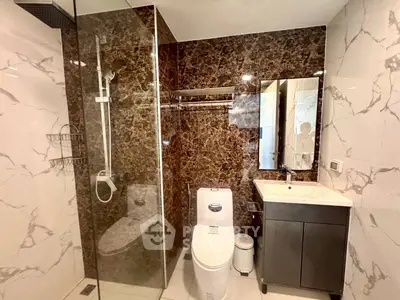 Luxurious bathroom with marble walls and modern fixtures in a high-end apartment.