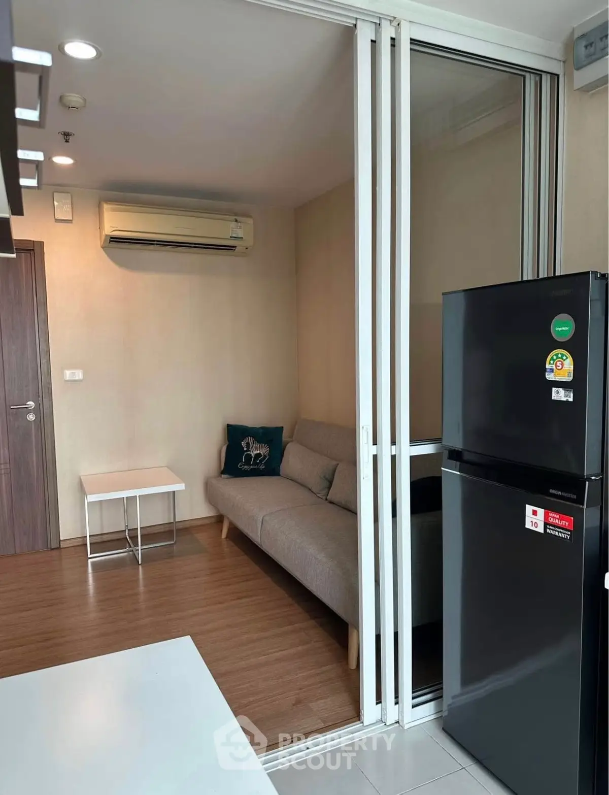 Modern living room with sliding glass doors and sleek black refrigerator