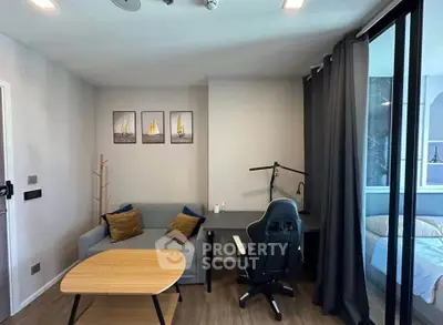 Modern living room with cozy sofa, stylish desk, and gaming chair in a chic apartment.