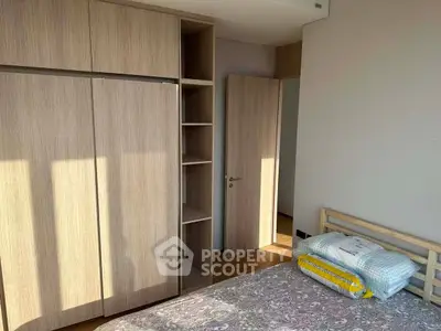 Spacious bedroom with wooden wardrobe and natural light, perfect for cozy living.