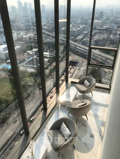 Stunning high-rise balcony with panoramic city views and elegant seating area.