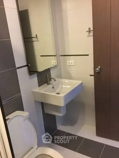 Modern bathroom with sleek sink and toilet in stylish design.