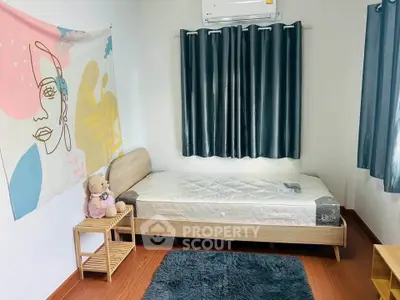 Cozy bedroom with modern decor and wooden flooring, featuring a single bed and stylish wall art.