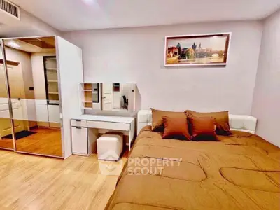Modern bedroom with stylish decor and ample storage space, featuring a cozy bed and elegant vanity.