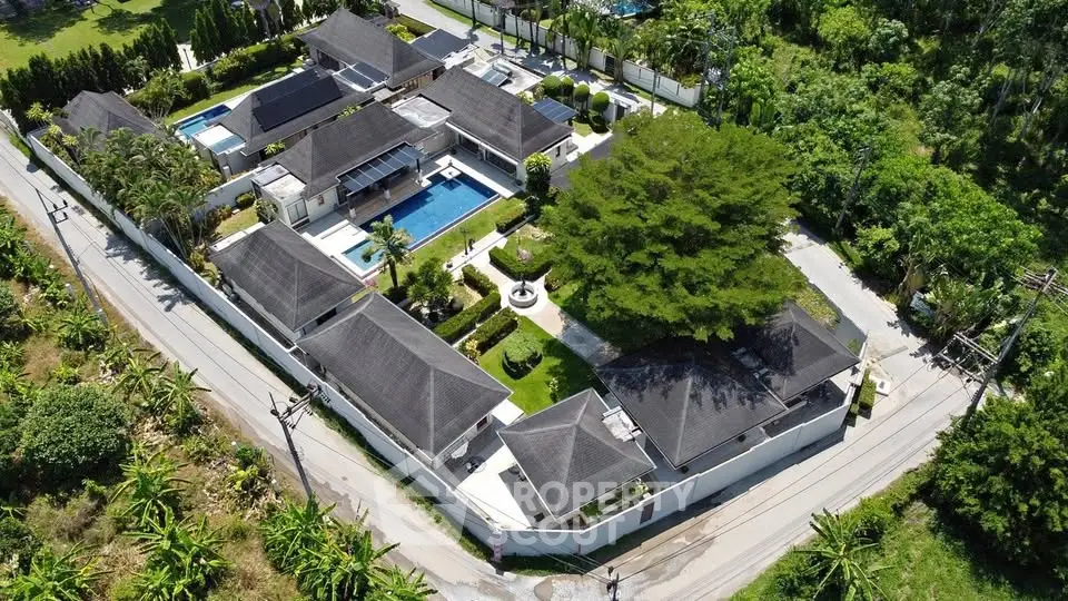 Luxurious aerial view of a private villa estate with pool and lush greenery