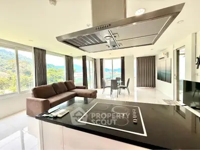 Spacious open-plan living room with modern kitchen and stunning mountain views.