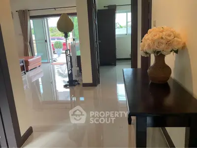 Spacious living area with elegant decor and natural light, featuring a stylish vase and modern furnishings.