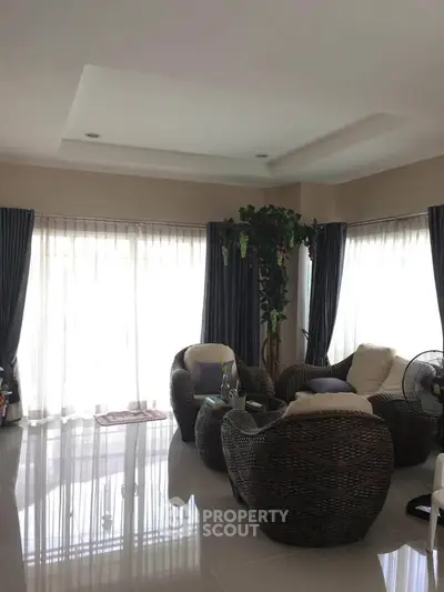 Spacious living room with wicker furniture and large windows for natural light