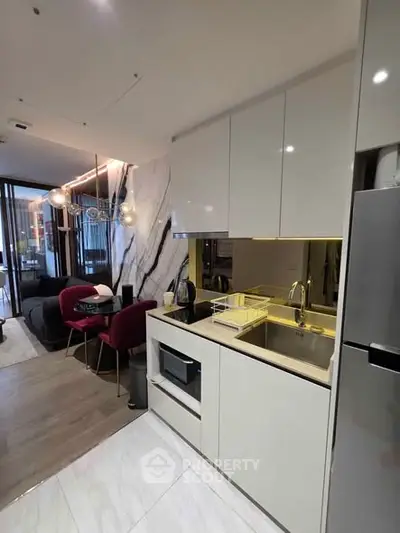 Modern open-layout kitchen with sleek cabinetry and integrated appliances in a stylish apartment.
