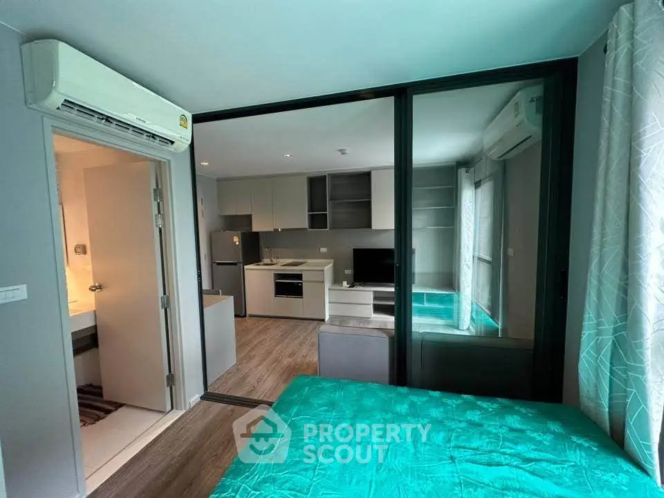 Modern apartment interior with open layout, featuring a cozy living area and sleek kitchen design.