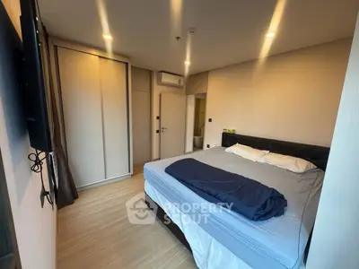 Modern bedroom with cozy bed and built-in wardrobe, featuring warm lighting and minimalist design.