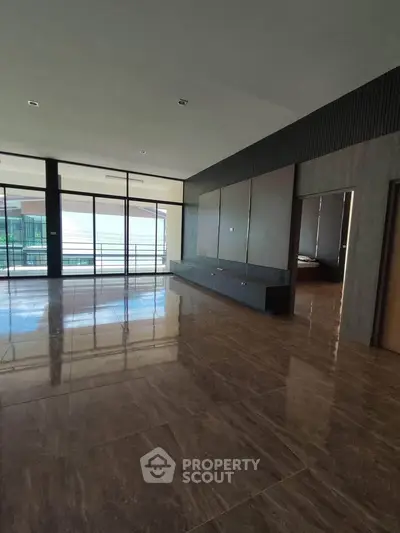 Spacious modern living room with large windows and elegant flooring