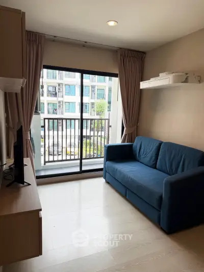 Modern living room with blue sofa and large window overlooking urban view